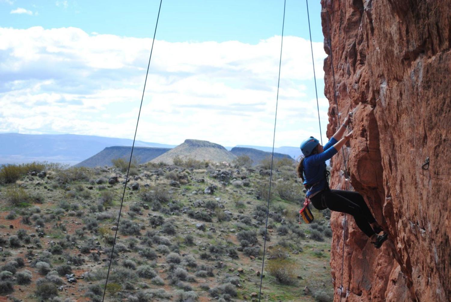 student climbing a rock face